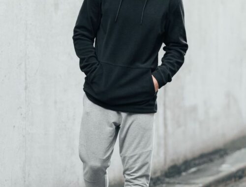 Un homme portant une tenue de type sportswear d'un jogging et d'un sweatshirt à capuche